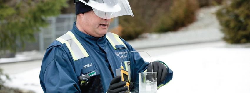 Man in a FortisBC jacket tests the temperature of LNG
