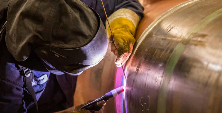 Welder works on pipe welds