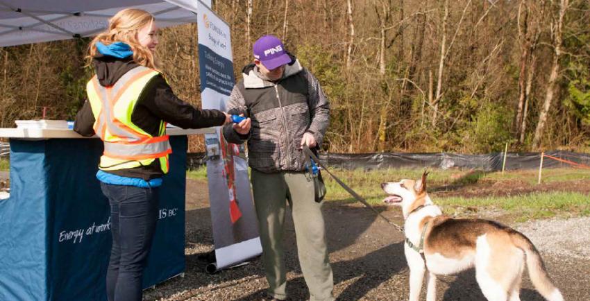 Woman talks to man holding a dog on a leash