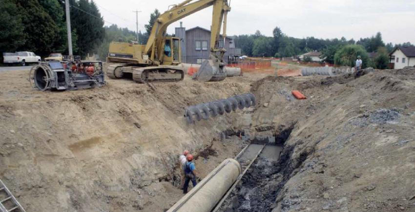 Excavator at the edge of a pipeline trench