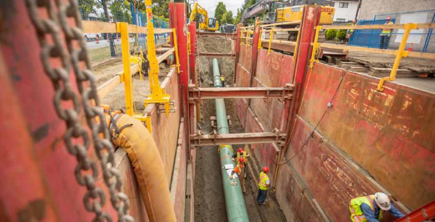 Three workers inside a gas line trench