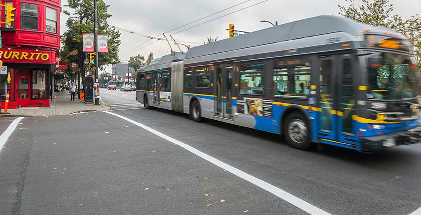 A bus drives down Commercial Drive in Vancouver