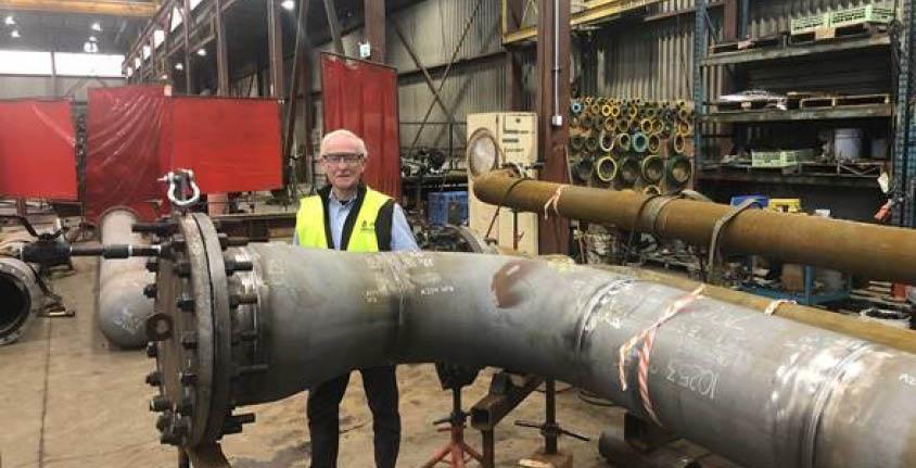 Jim Longo, President, Ideal Welders wears safety glasses and vest and smiles at the camera