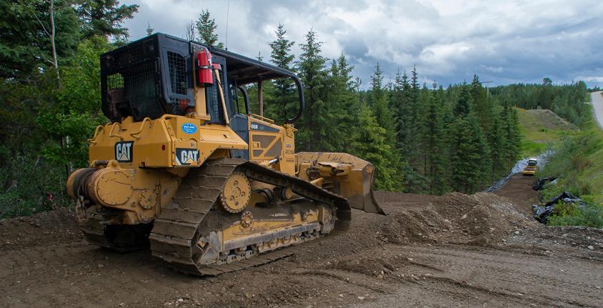 Bulldozer sits on a hill along a right of way clearing