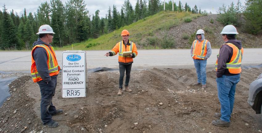 4 workers stand around a Duz Cho sign on a work site