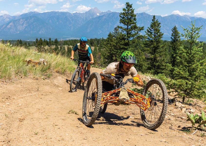 two mountain bikers ride up a trail
