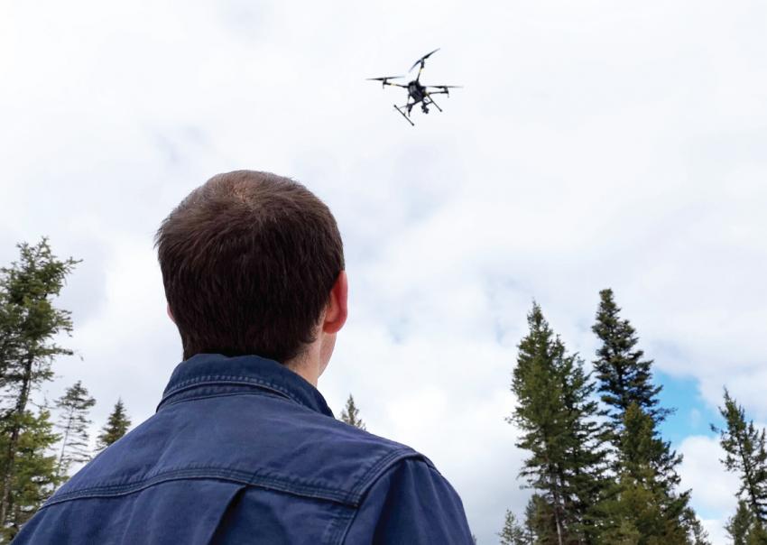 Man looks up at flying drone