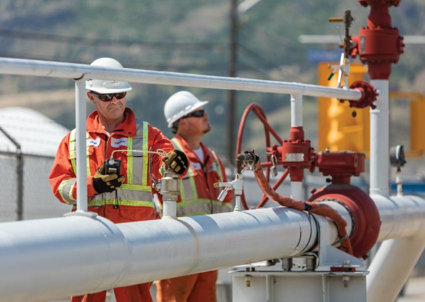 Two workers inspect gas lines