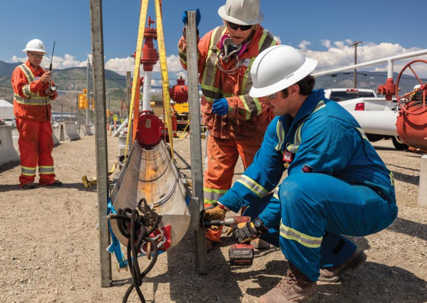 Two men work on a pipeline