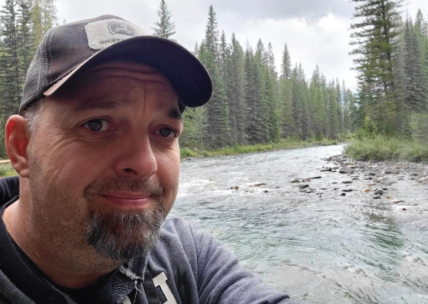 Man takes a selfie with river in background