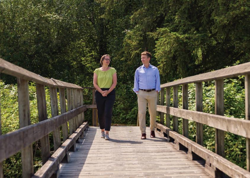 Linda Bakker and Will Hyde walk along a bridge in Burnaby Lake Park