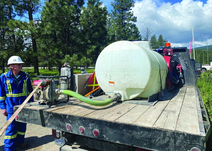 A water tank on the back of a flatbed truck