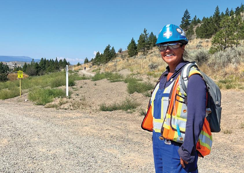 Vi Antione smiles at the camera while standing on a right of way trail in Kenna Cartwright Park