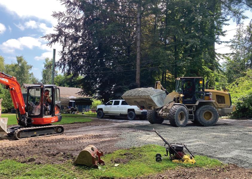 a bulldozer carries a scoop of gravel on a driveway along the PGR route