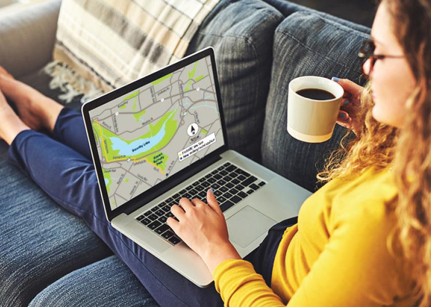 Woman sits on a couch looking at a map of the PGR route