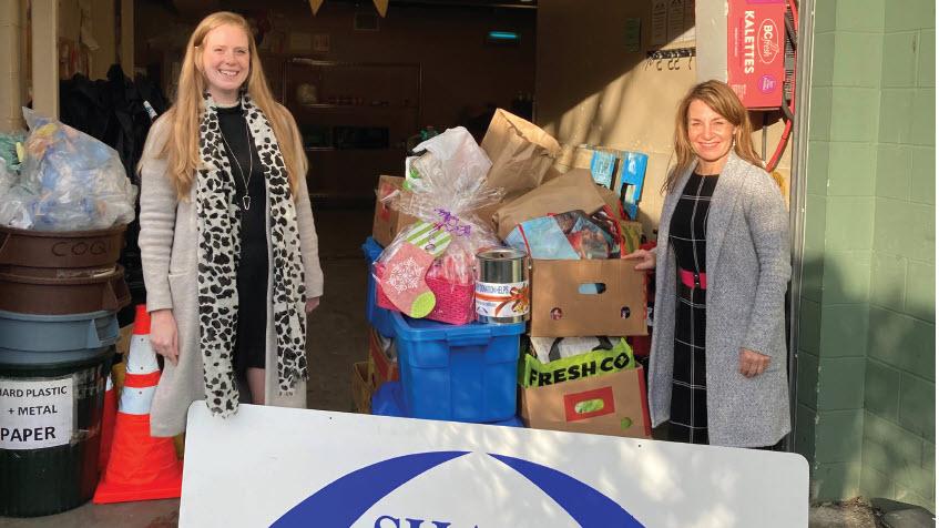 FortisBC team members stand outside SHARE with a pile of food for the food bank