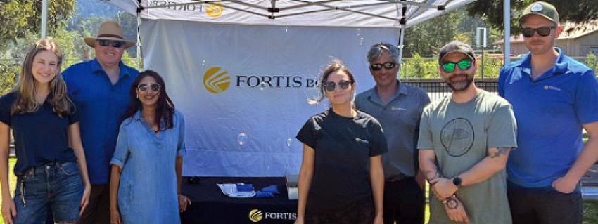 A group of seven people standing in front of a Fortis BC banner at the Squamish Days Loggers Sports Festival