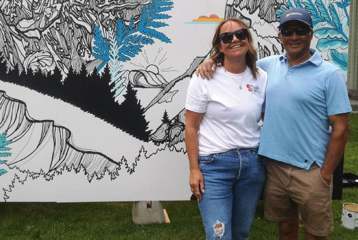 Kerry Neil, executive director, Squamish Downtown Business Improvement Association and FortisBC’s Elliot Moses are standing in front of a mural painted by Kate Zessel.