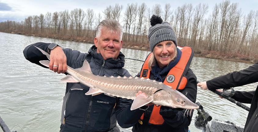 Proud anglers display large sturgeon catch on winter fishing trip