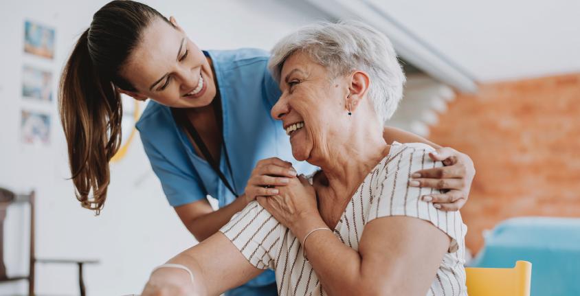 Healthcare worker and elderly patient share joyful moment together