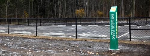 A fence surrounds the parking lot at Carlson Park